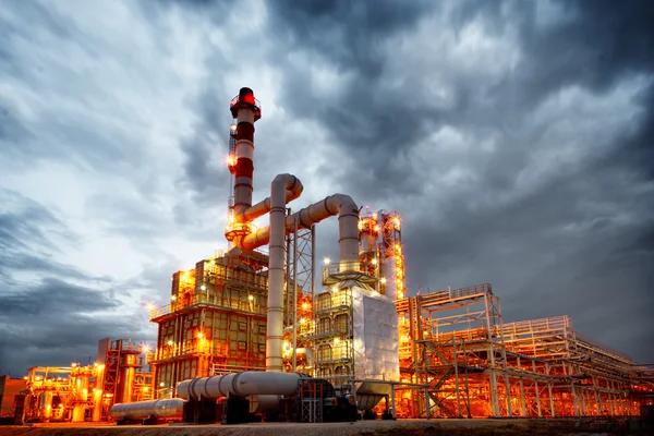 Oil refinery at golden hour — industrial towers and infrastructure